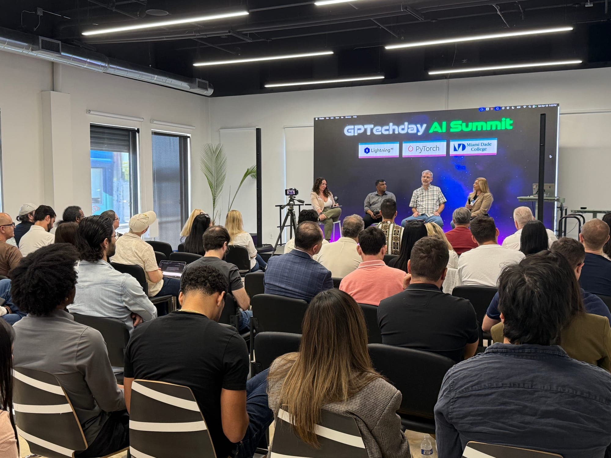 A panel on stage at a DeepStation AI summit, in front of a seated audience
